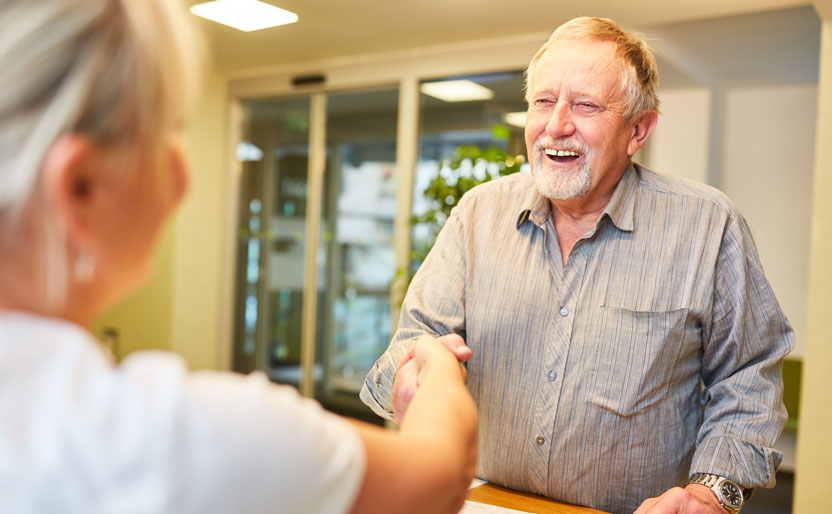 Blaine & Birch Bay Family Dentistry | Dentist smiling while showing a young patient a dental model during a consultation